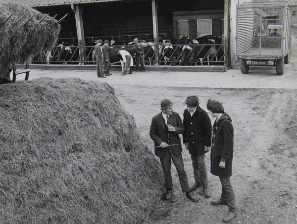 Students and lecturers in front of farm buildings