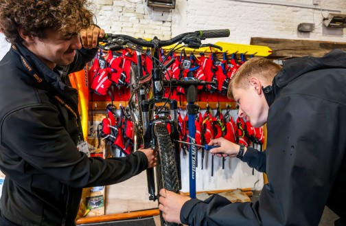 Two Outdoor Leadership students fixing a bike
