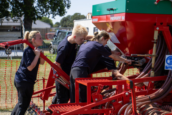 Four students working together to calibrate a seed drill